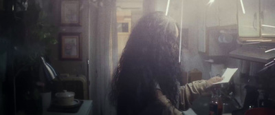 a woman with long hair standing in a kitchen