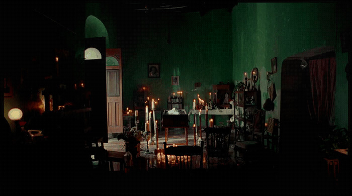 a dark room with candles and a table