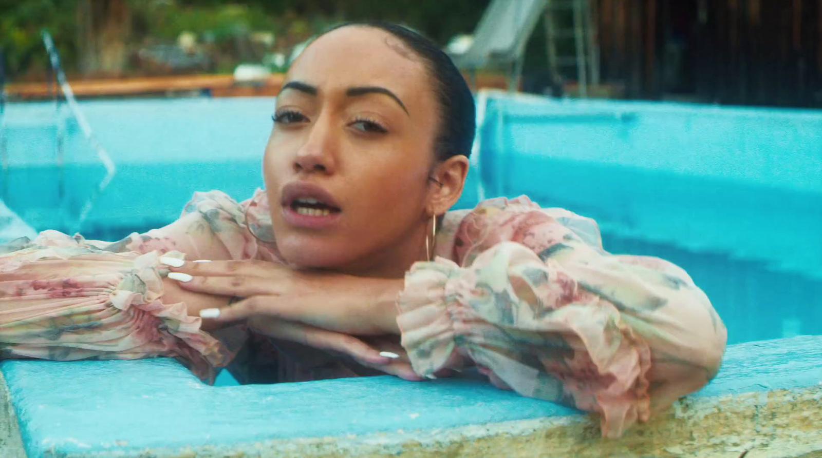 a woman in a pool with her hands on her chest