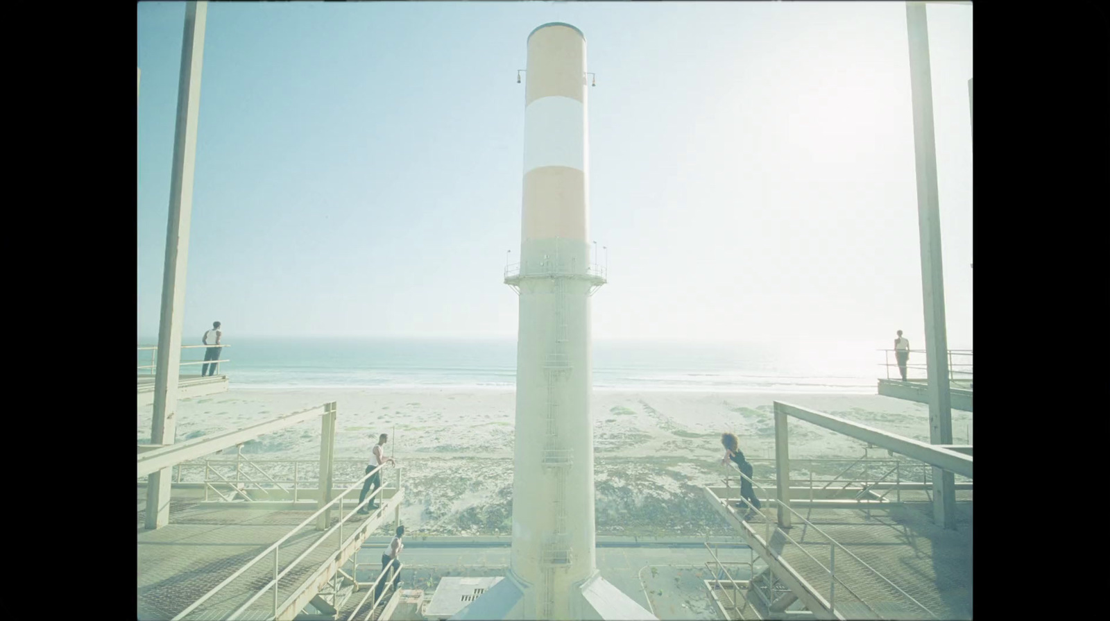 a tall white tower sitting on top of a sandy beach