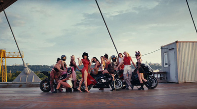 a group of women standing next to each other near a motorcycle