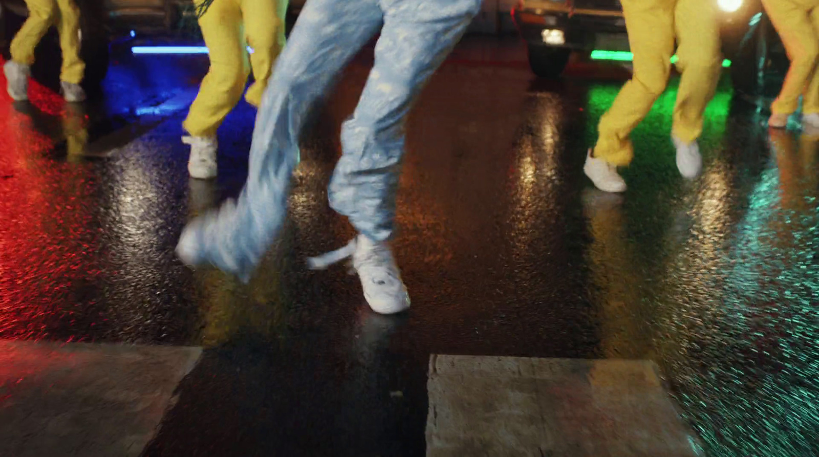 a group of people dancing on a wet street