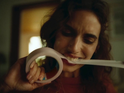 a woman brushing her teeth with a toothbrush