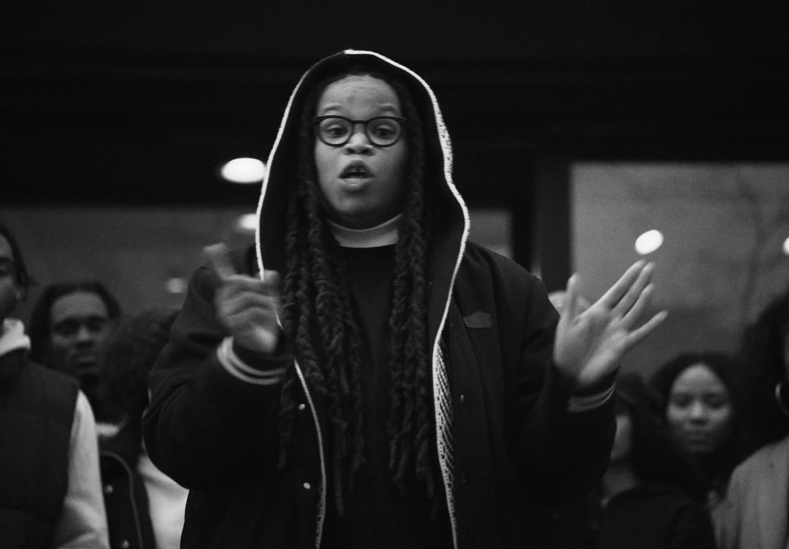 a black and white photo of a man with dreadlocks