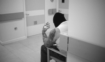 a man sitting on top of a chair in a bathroom