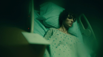 a woman laying in a hospital bed in the dark