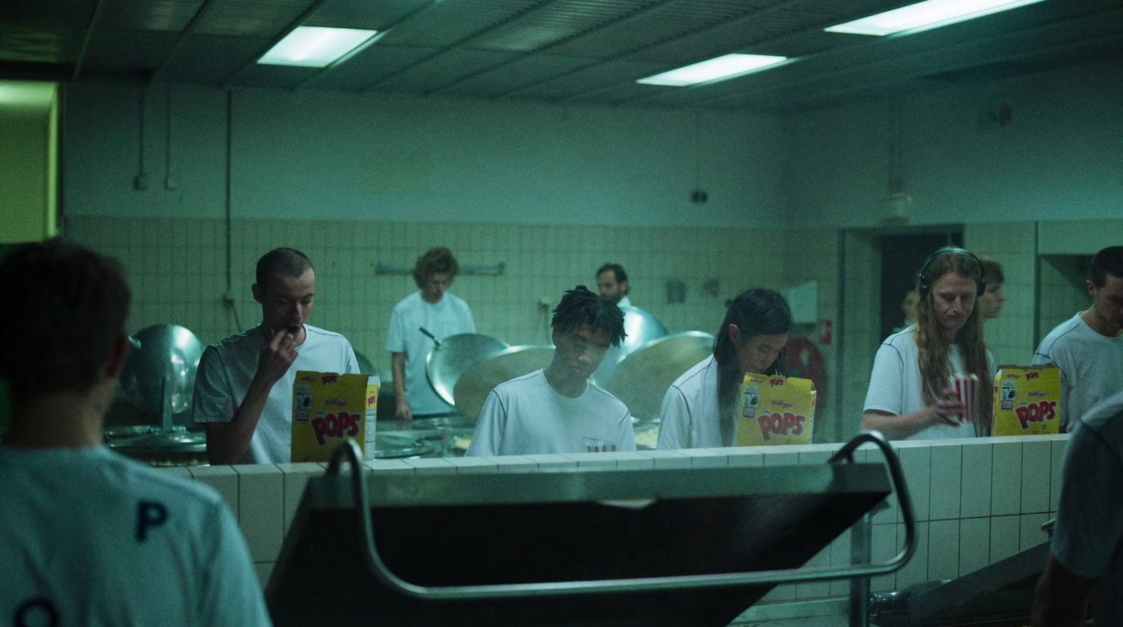 a group of people standing around a kitchen