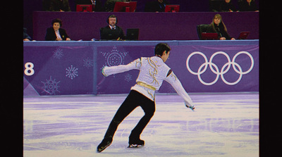 a man skating on an ice rink in front of a crowd