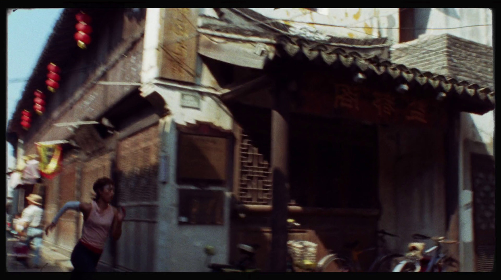 a woman walking down a street next to a building