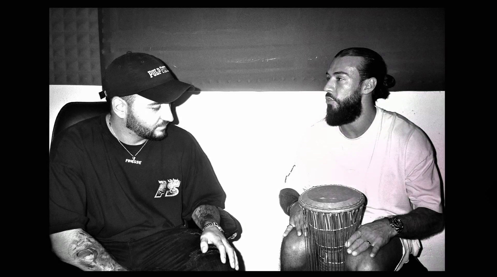 a black and white photo of two men sitting next to each other