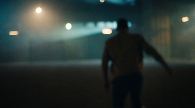 a blurry image of a man riding a skateboard at night