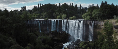 a large waterfall in the middle of a forest