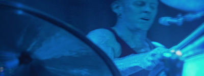 a man playing drums in a dark room