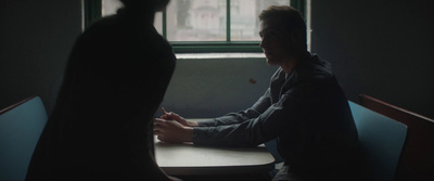 a man sitting at a table in front of a window