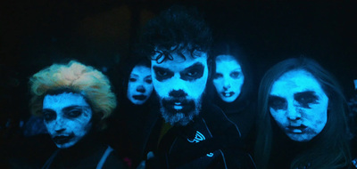 a group of people with painted faces in the dark