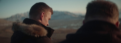 a man in a fur coat looking at another man in a fur coat