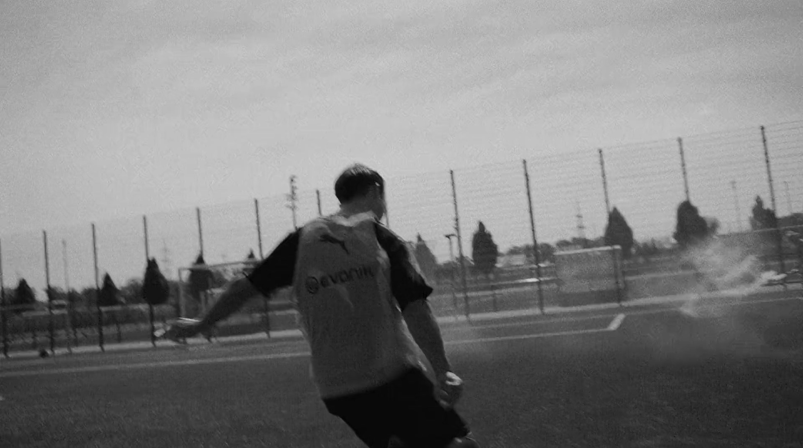 a man standing on top of a field holding a soccer ball