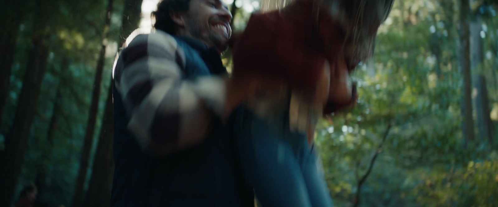 a blurry photo of a man and a woman in the woods