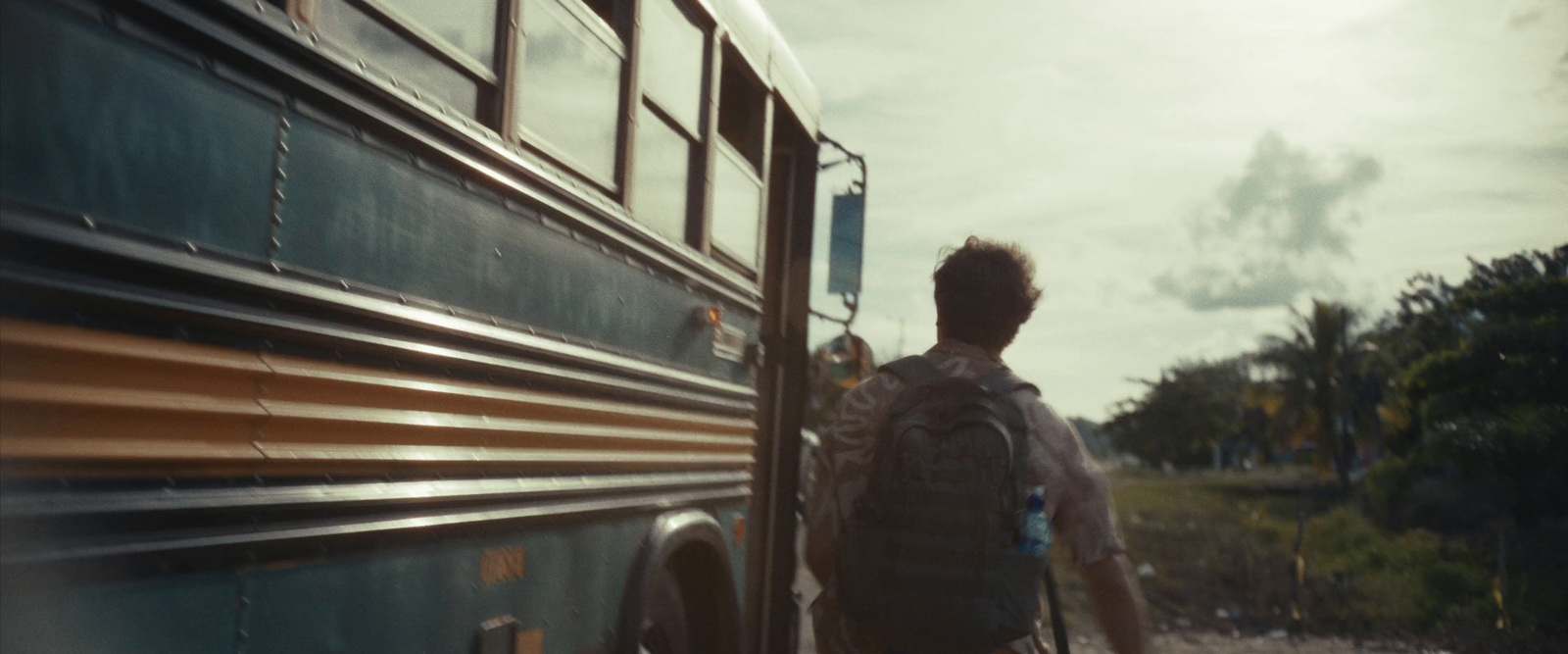 a man with a backpack is getting off of a bus