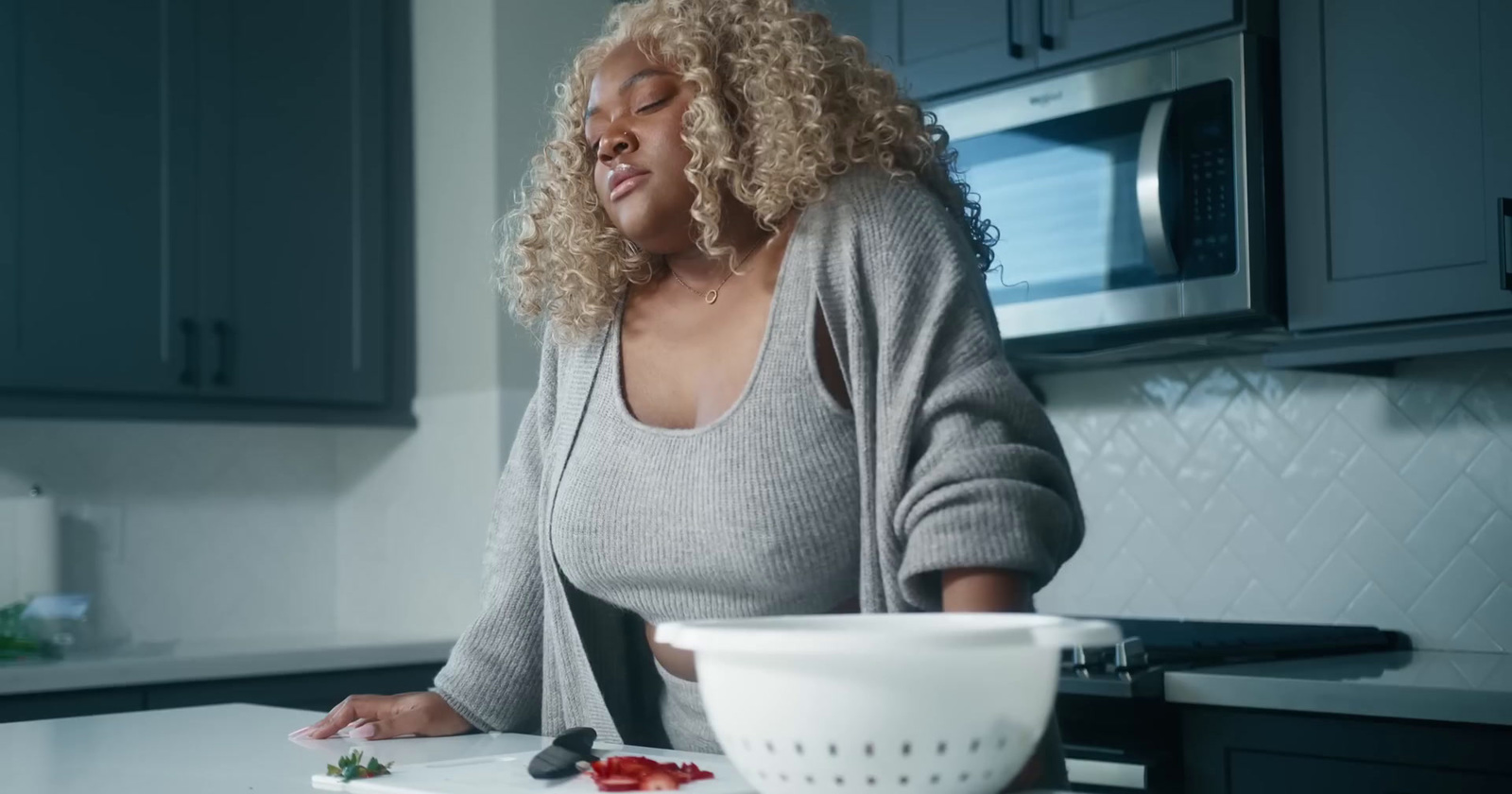 a woman standing in a kitchen preparing food