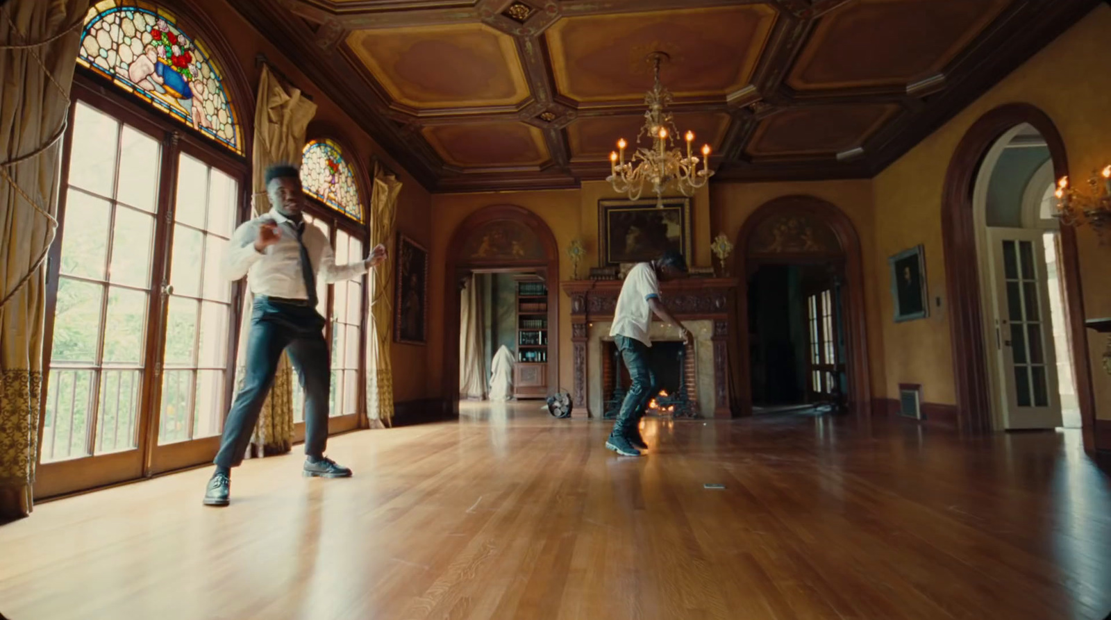 a couple of people standing on top of a hard wood floor