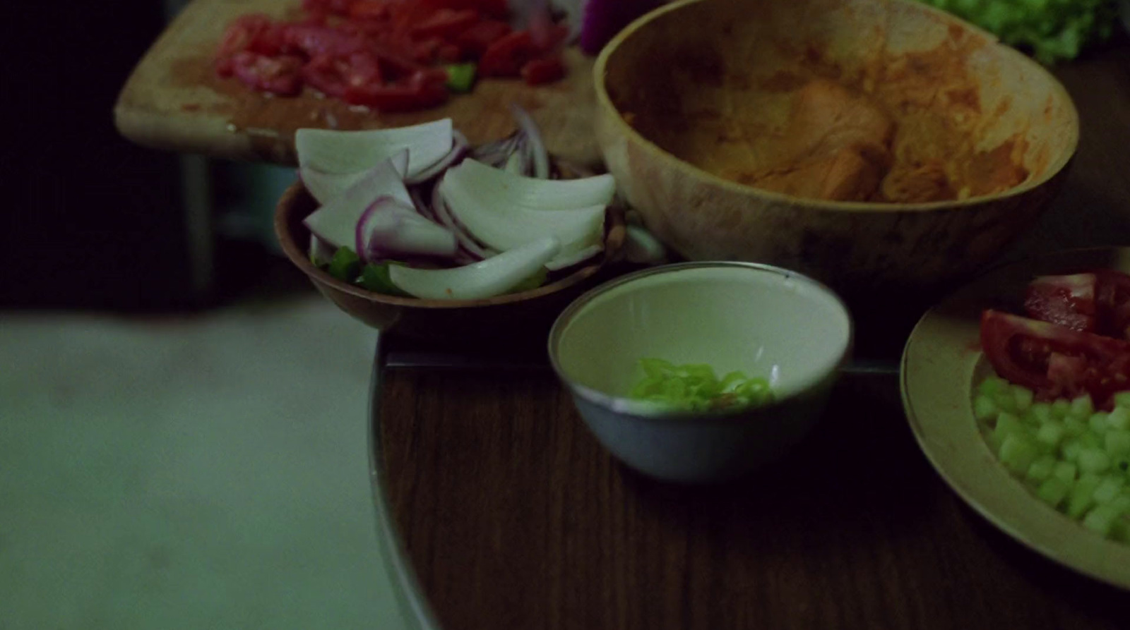 a wooden table topped with bowls filled with food