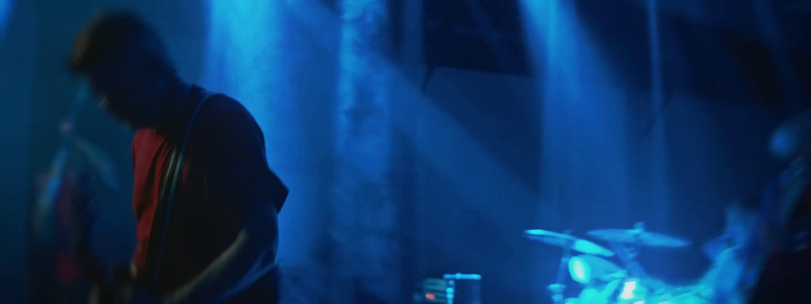 a man standing in front of a drum set