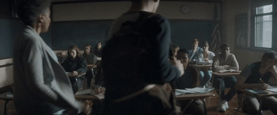 a group of people sitting at desks in a classroom