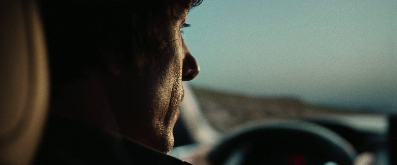 a man sitting in a car looking out the window