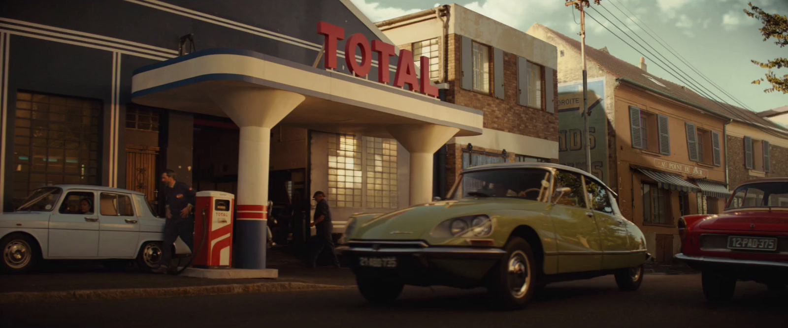 a yellow car parked in front of a gas station