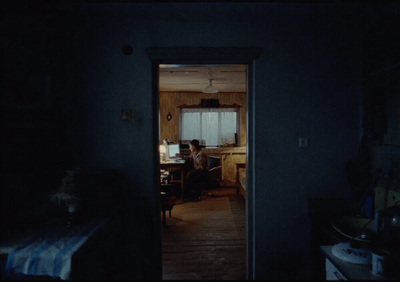 a person sitting at a table in a dark room