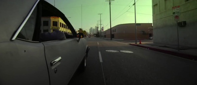 a car driving down a street next to tall buildings