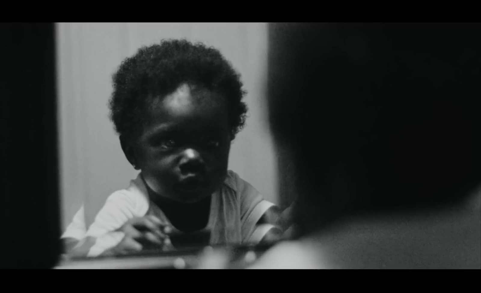 a young child is looking in the mirror