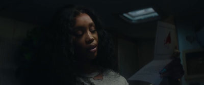 a woman with long hair standing in a dark room