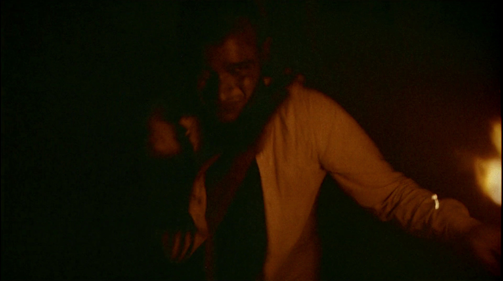 a man standing in a dark room with his hands on his hips