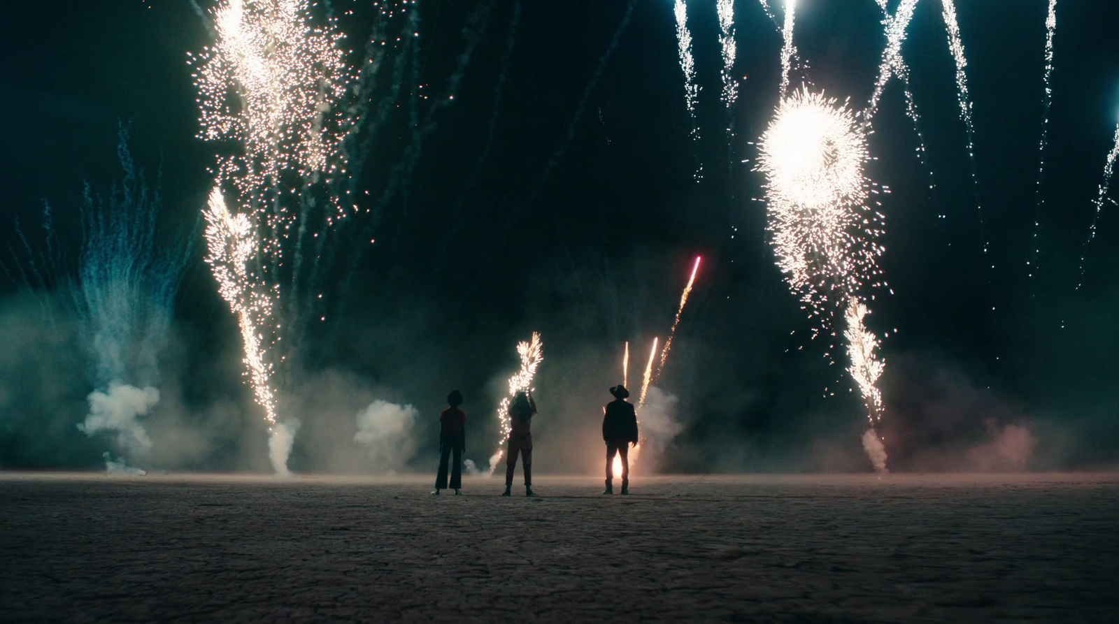 a couple of people standing in front of fireworks