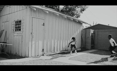 a black and white photo of two boys playing with a frisbee