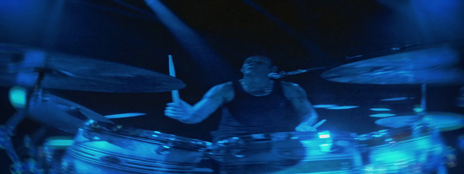 a man playing drums in a dark room