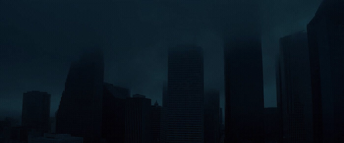 a dark cityscape with tall buildings in the background