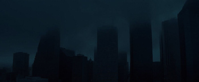 a dark cityscape with tall buildings in the background