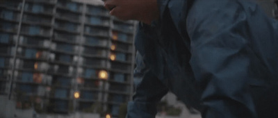 a man walking down a street next to a tall building