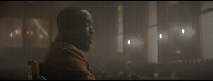 a man sitting in a chair in a dimly lit room