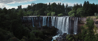 a large waterfall surrounded by lush green trees