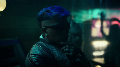 a man with blue hair and sunglasses holding a gun