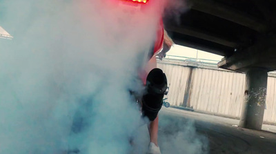 a person standing next to a car with smoke coming out of it