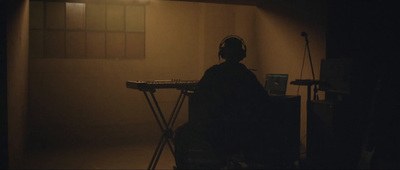 a person sitting at a keyboard in a dark room