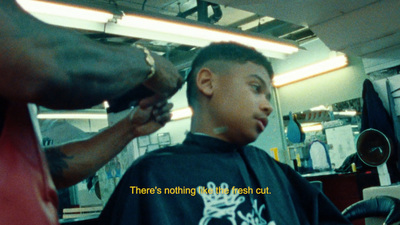 a man getting his hair cut in a barber shop