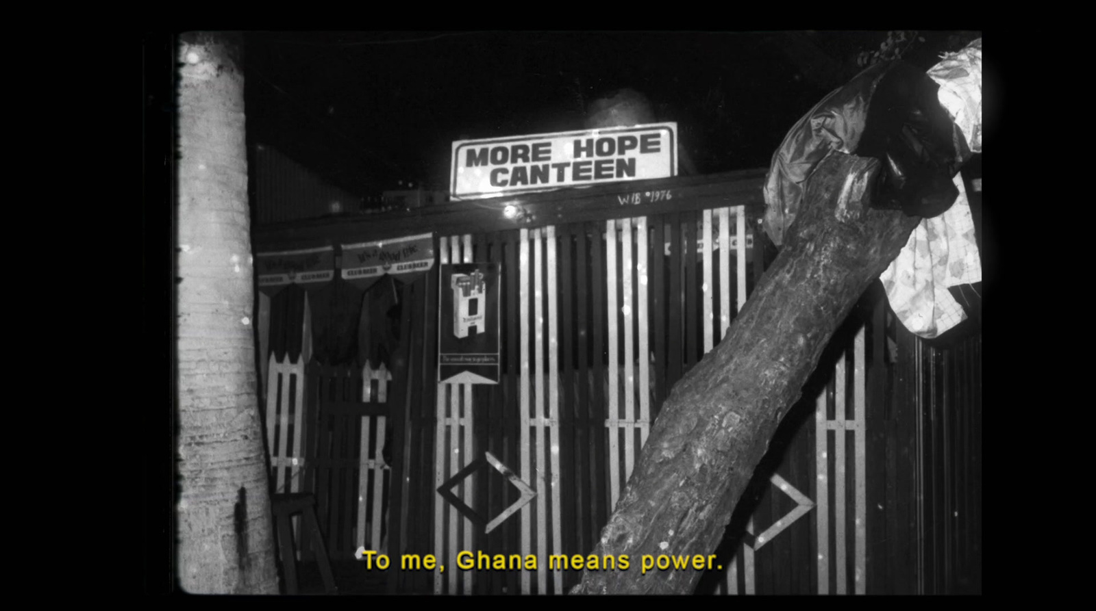 a black and white photo of a sign on a fence