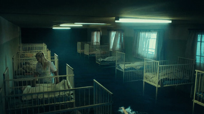 a woman in a white dress standing in a room with bunk beds