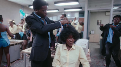 a man cutting a woman's hair in an office